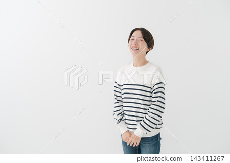 A woman in her 40s wearing a striped top. A woman in her 40s wearing a striped top. 143411267