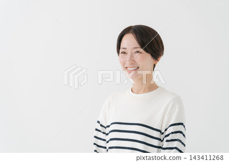 A woman in her 40s wearing a striped top. A woman in her 40s wearing a striped top. 143411268