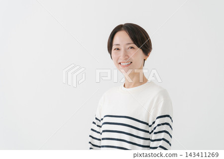 A woman in her 40s wearing a striped top. A woman in her 40s wearing a striped top. 143411269