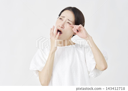 一位中年婦女在白色背景前打哈欠。 143412718
