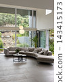 Curved gray sectional sofa occupying lower half, anchoring living room with nested coffee tables 143415173