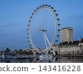 The London Eye, a giant Ferris wheel towering over the Thames River, and the cityscape at sunset in London. 143416228