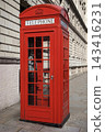 A traditional red telephone box stands on a street corner in London, England. 143416231