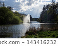 Fountain rising into the pond in St. James's Park, with sunlight streaming through the clouds - London 143416232