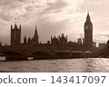 A sepia-toned view of the Houses of Parliament and Big Ben on the Thames River in London. 143417097