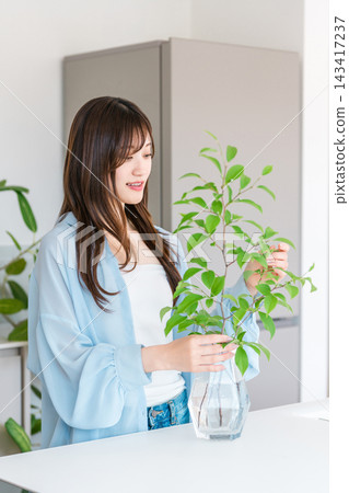 花瓶,年輕女子把植物放在花瓶裡 花瓶,年輕女子把植物放在花瓶裡 143417237