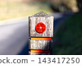 Weathered wooden post stands beside asphalt road 143417250