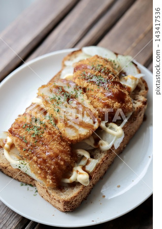 用全麥麵包做成的開放式三明治,裡面夾著洋蔥和炸丸子。 用全麥麵包做成的開放式三明治,裡面夾著洋蔥和炸丸子。 143417536