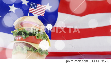 Showcasing stacked cheeseburger on studio tabletop with US flag toothpick, American flag backdrop Showcasing stacked cheeseburger on studio tabletop with US flag toothpick, American flag backdrop 143419476