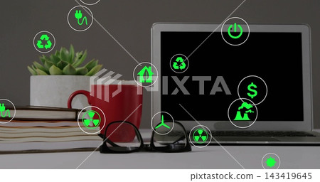 Displaying silver laptop on right of office desk, with books, red mug, green icons, copy space Displaying silver laptop on right of office desk, with books, red mug, green icons, copy space 143419645