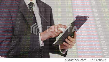 Tapping man in suit and tie holding tablet swiping screen in office showing stock data overlay Tapping man in suit and tie holding tablet swiping screen in office showing stock data overlay 143420504