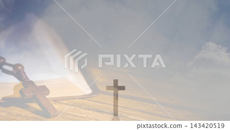 Resting wooden rosary and open book lying on wooden tabletop, with small upright cross silhouette Resting wooden rosary and open book lying on wooden tabletop, with small upright cross silhouette 143420519