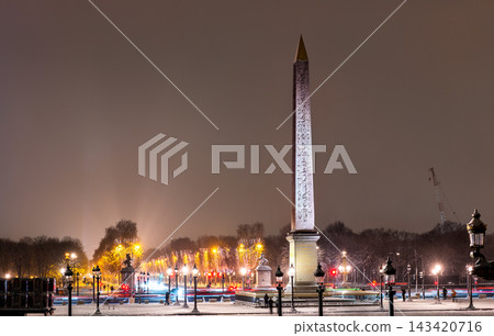 Illuminated Luxor Obelisk and evening traffic lights on snow covered Place de la Concorde in Paris, France during winter Illuminated Luxor Obelisk and evening traffic lights on snow covered Place de la Concorde in Paris, France during winter 143420716