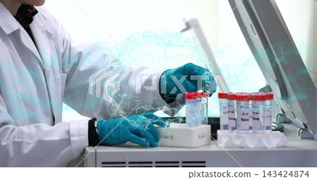 Handling lab tech in white coat, teal gloves using bench instrument, with rack of red-capped vials Handling lab tech in white coat, teal gloves using bench instrument, with rack of red-capped vials 143424874