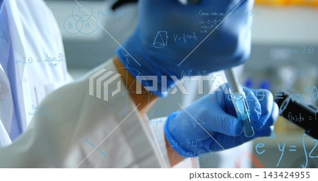 Using pipette hand wearing blue-nitrile-gloves moving blue liquid into vial at lab labcoat formulas Using pipette hand wearing blue-nitrile-gloves moving blue liquid into vial at lab labcoat formulas 143424955