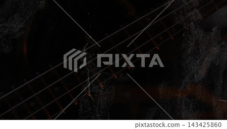 Highlighting guitar neck close-up in dark room, six strings frets dot inlays grunge texture 143425860