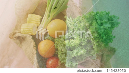Showing top view produce cluster sitting on burlap tabletop, with corn scallions citrus tomato kale 143428050