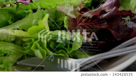 Showing red-green lettuce shining with droplets on tabletop with white plate utensils bar charts Showing red-green lettuce shining with droplets on tabletop with white plate utensils bar charts 143428535