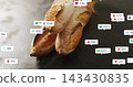 Displaying three crusty baguettes resting on slate tabletop surrounded by social icons and crumbs 143430835