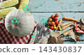 Displaying pale green pumpkin on red-white checkered cloth on turquoise table, with neon icons 143430837