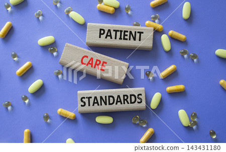 PATIENT CARE STANDARDS symbol. Concept words PATIENT CARE STANDARDS on wooden blocks. Beautiful purple background with pills. Healthcare and PATIENT CARE STANDARDS concept. Copy space. PATIENT CARE STANDARDS symbol. Concept words PATIENT CARE STANDARDS on wooden blocks. Beautiful purple background with pills. Healthcare and PATIENT CARE STANDARDS concept. Copy space. 143431180