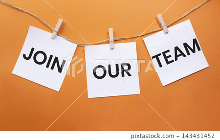 Join Our Team text on white paper notes hanging on rope with clothespins over orange background. Recruitment and employee engagement concept with copy space. Join Our Team text on white paper notes hanging on rope with clothespins over orange background. Recruitment and employee engagement concept with copy space. 143431452