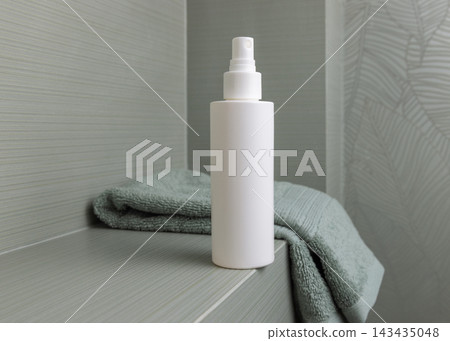 White cosmetic spray borttle mockup on light green towel in bathroom, unbranded packaging 143435048