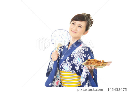 一位身穿浴衣的女子手捧烤雞串。 一位身穿浴衣的女子手捧烤雞串。 143438475