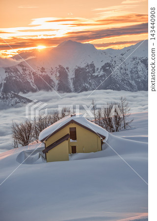 Yellow house almost buried in deep snow at mountain sunset Yellow house almost buried in deep snow at mountain sunset 143440908