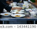 chefs in a professional kitchen garnishing dessert plates with precision. restaurant chef team showcasing fine dining presentation, culinary creativity, and teamwork in food preparation. 143441190