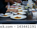 chefs in a professional kitchen garnishing dessert plates with precision. restaurant chef team showcasing fine dining presentation, culinary creativity, and teamwork in food preparation. 143441191