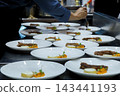 professional chef pouring brown sauce over stack meat decoration dishes during dinner food plating service in commercial restaurant kitchen. food service, hotel and restaurant cooking. 143441193