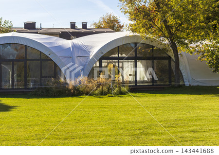 Large white dome event tent marquee on a green grass lawn. Celebration Large white dome event tent marquee on a green grass lawn. Celebration 143441688