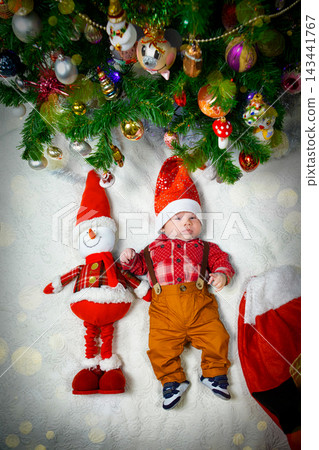 Baby and Snowman Toy Celebrate Christmas Under the Decorated Tree With Festive Ornaments Baby and Snowman Toy Celebrate Christmas Under the Decorated Tree With Festive Ornaments 143441767