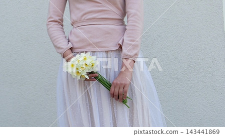 Cute woman holds a vibrant bouquet of yellow daffodil 143441869