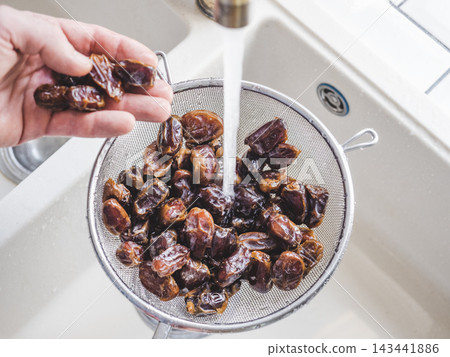 Male hands wash dried dates Male hands wash dried dates 143441886