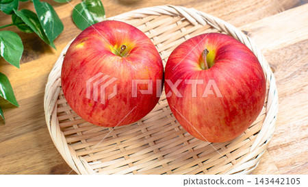 A photo of two Sun Tsugaru apples placed in a bamboo basket. A photo of two Sun Tsugaru apples placed in a bamboo basket. 143442105