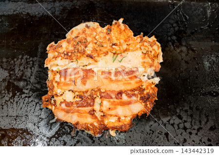 什錦豬肉大阪燒,在鐵板上烤至完美,上面鋪上豬肉。 什錦豬肉大阪燒,在鐵板上烤至完美,上面鋪上豬肉。 143442319