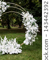 Elegant white flower arrangement on circular metal arch. 143442392