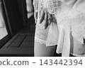 Close up of bride hand on lace stockings in robe black and white 143442394