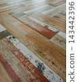 Distressed wood look ceramic floor tiles in herringbone pattern 143442396