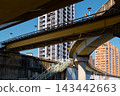 Overlapping elevated roads and a footbridge stair frame apartment towers 143442663