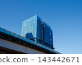 Blue netting covers a high-rise under construction beside an elevated viaduct 143442671