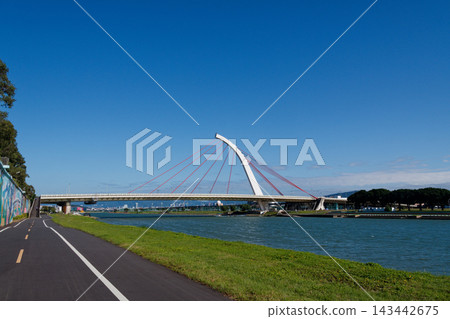 White arch Dazhi Bridge with red cables over the Keelung River on a sunny day White arch Dazhi Bridge with red cables over the Keelung River on a sunny day 143442675