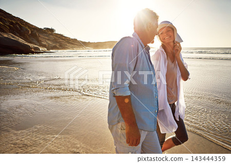 Senior, happy couple and walking with beach sunset for love, embrace or bonding together in nature. Man, woman or lovers holding hands with smile for summer holiday by water, sea or ocean coast Senior, happy couple and walking with beach sunset for love, embrace or bonding together in nature. Man, woman or lovers holding hands with smile for summer holiday by water, sea or ocean coast 143444359