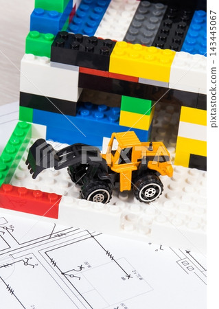 Housing plan with electric installation, house under construction made of toy blocks Housing plan with electric installation, house under construction made of toy blocks 143445067
