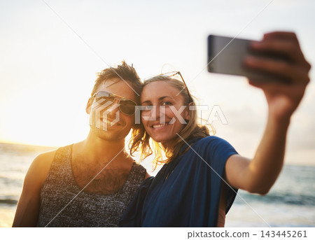 Man, woman and selfie at beach for sunset, travel and vacation to island in summer for love. Happy, couple and technology for holiday with sunshine, smile and people together for date in Thailand 143445261