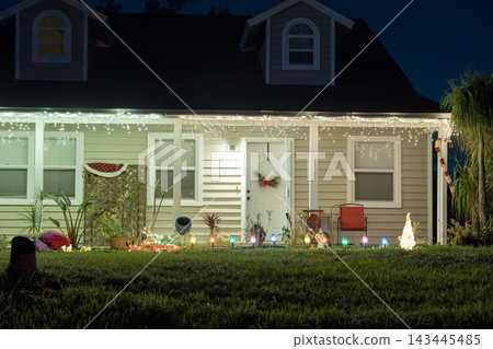 Festive yard display with glowing lights and Christmas decorations at a Florida family home. New Year holiday joy. Festive yard display with glowing lights and Christmas decorations at a Florida family home. New Year holiday joy. 143445485