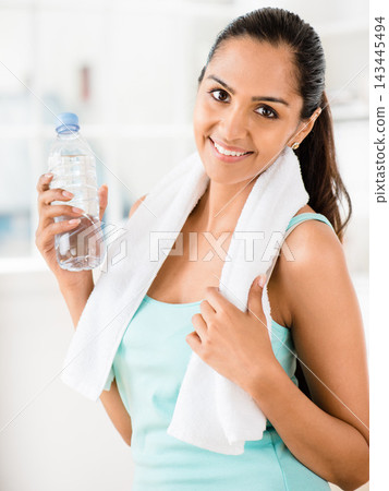 Athlete, portrait and woman for fitness with towel, training and sports for health with water. Face, bottle and strong female person in sportswear and sweat cloth, exercise or performance in studio 143445494