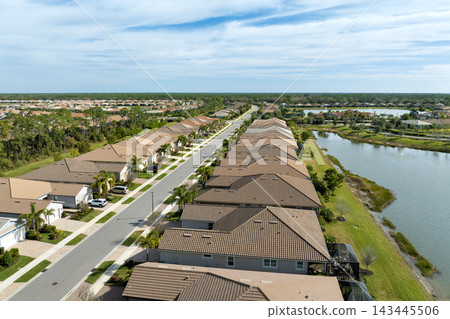 Expensive mansions between green palm trees in southwest Florida suburbs, USA. Aerial view of wealthy residential neighborhood Expensive mansions between green palm trees in southwest Florida suburbs, USA. Aerial view of wealthy residential neighborhood 143445506